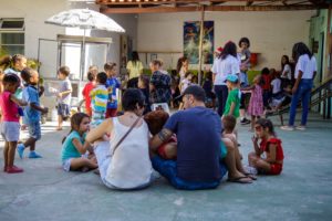 Voluntários e crianças se divertem juntos em dia de ação solidária celebrando o natal.